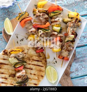 Spiedini di pollo alla griglia e verdure serviti con pane naan alla griglia. Foto Stock