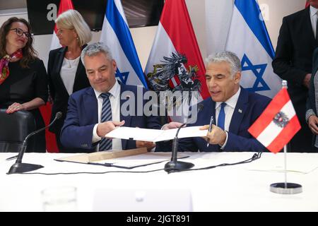 GERUSALEMME, 13 luglio 2022 (Xinhua) -- il Cancelliere austriaco Karl Nehammer (L) e il primo Ministro israeliano Yair Lapid partecipano ad una cerimonia di firma a Gerusalemme il 12 luglio 2022. Martedì Israele e l'Austria hanno firmato un accordo per la creazione di un "partenariato strategico globale" per ampliare la cooperazione in materia di sicurezza. (Shaol Golan/JINI via Xinhua) Foto Stock