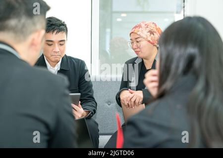 Dirigenti di ufficio di affari etnia asiatica seduta su un divano che ha una riunione di progetto. Foto Stock