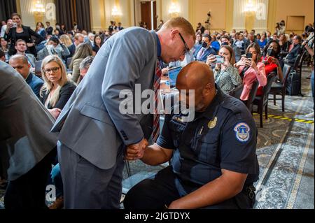 Washington, DC, USA, luglio 12, 2022. Stephen Ayres, a sinistra, che ha supplicato colpevole di entrare illegalmente nel Campidoglio il 6 gennaio, parla con l'ufficiale della polizia del Campidoglio americano Harry Dunn, a destra, dopo il giorno sette del Comitato di selezione della Camera degli Stati Uniti per indagare sull'attacco del 6th gennaio all'udienza del Campidoglio degli Stati Uniti a Capitol Hill a Washington, DC, USA il 12 luglio 2022. Foto di Rod Lammey/CNP/ABACAPRESS.COM Foto Stock