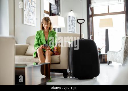 Una donna d'affari attende nella hall dell'hotel Foto Stock