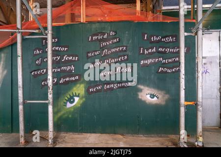 Durante i molti anni in cui era un cantiere, il Chelsea Hotel di Manhattan è stato sommersi di impalcature e legno compensato, qui dipinte con una poesia. Foto Stock