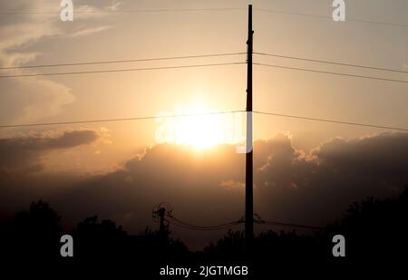 (220713) -- HOUSTON, 13 luglio 2022 (Xinhua) -- il sole tramonta dietro le linee di trasmissione di potenza in Texas, gli Stati Uniti il 11 luglio 2022. L'Electric Reliability Council of Texas (ERCOT) lunedì ha chiesto ai residenti e alle imprese di ridurre il loro consumo di energia, in quanto l'indice di calore ha superato i 100 gradi Fahrenheit in circa la metà dello stato del centro meridionale degli Stati Uniti. Questa ondata di calore è iniziata più di una settimana fa ed è ancora forte, sfidando la rete elettrica dello stato. Le temperature quasi record in gran parte del Texas hanno costretto vari eventi all'aperto a subire ritardi o cancellazioni per problemi di sicurezza. (Punto Foto Stock