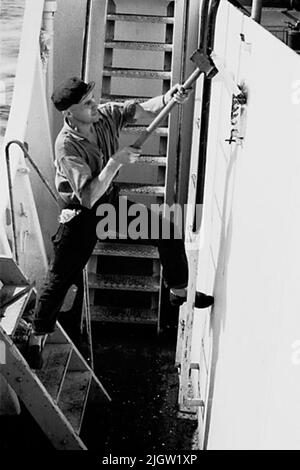 La foto è stata scattata intorno al 1961-09-22. Un uomo si alza su una barca e colpisce con un martello a mazza su una trave. African travel35 immagini in serie. Foto Stock
