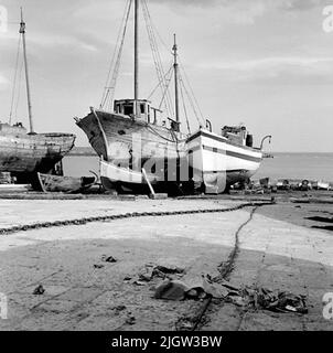 15. Italia. Il giornale fotografico è disponibile presso B.M.A. + Album fotografici. Acquisizione: Libri e materiale di archivio. Foto scattate 1959-10-28,12 Foto in serie. Secondo le note: Italia. Costa Adriatica, Trani, 28/10 -59. Cantieri navali. Un paio di barche sono commissionate a terra in un porto. Un uomo si siede in una delle barche e lavora con l'interno. Foto Stock