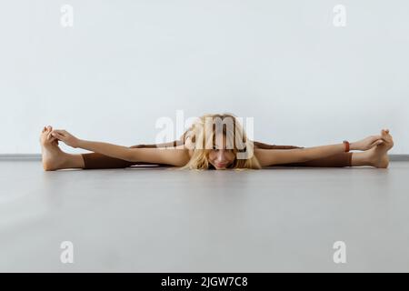 Giovane donna attraente fitness esecuzione spago, Upassta Konasana Foto Stock