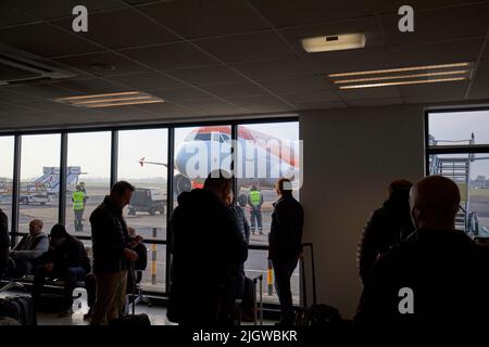 passeggeri easyjet in attesa della partenza del volo aereo all'aeroporto internazionale di belfast nel regno unito Foto Stock