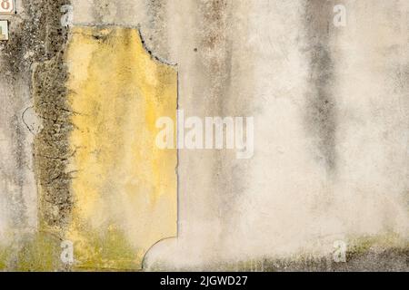 Primo piano di un vecchio muro urbano con peeling e intonaco rotto a Villes-sur-Auzon, Francia. Spazio di copia di sfondo. Foto Stock