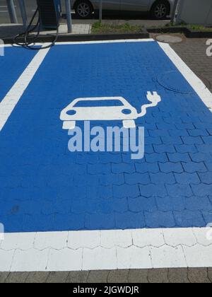 Colonia, Germania. 08th luglio 2022. Pittogramma con simbolo su sfondo blu per la stazione di ricarica in una stazione di ricarica rapida per auto elettriche. Solo le e-car sono autorizzate a stare qui per il momento della ricarica. Credit: Horst Galuschka/dpa/Alamy Live News Foto Stock