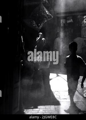 Lo scatto verticale in scala di grigi dei bambini in un mercato urbano povero Foto Stock