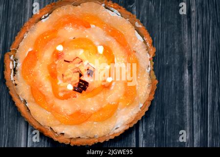 Una torta di frutta con candele di compleanno con pezzi freschi di mela, fette di spiaggia fresca e ananas con panna montata a base di un semplice Foto Stock