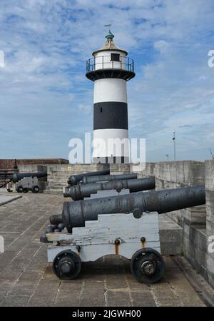 Il faro all'interno del castello di Southsea a Portsmouth insieme ad alcuni cannoni che difendono i bastioni. Foto Stock