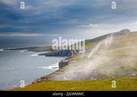 Guardando verso Neist Point in 40 miglia all'ora mentre si cerca di rimanere in piedi, Isola di Skye, Scozia Foto Stock