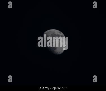 Un primo piano di una luna che illumina un cielo notturno scuro Foto Stock