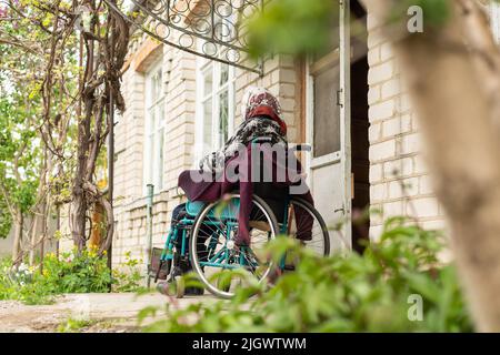 Donna anziana seduta su una sedia a rotelle che sembra triste e preoccupato: Depressione, assistenza sanitaria e cura per gli anziani Foto Stock