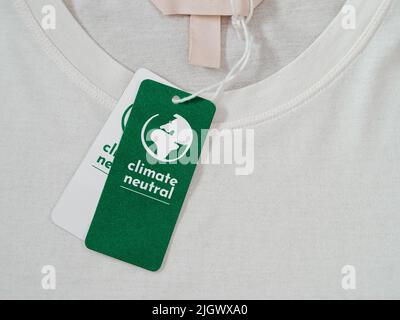 T-shirt in carbonio neutro, etichetta clima neutro su abiti nuovi. Concetto di etichetta a zero emissioni di carbonio nell'abbigliamento, nell'industria della moda. Ethical Consumption.Inviting awareness for customers - Carbon footpint Foto Stock