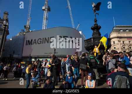 “IMMAGINE PEACE”, un messaggio di Yoko Ono viene visualizzato sul grande quadro elettrico durante la marcia “London Stands with Ukraine” a Londra. Foto Stock