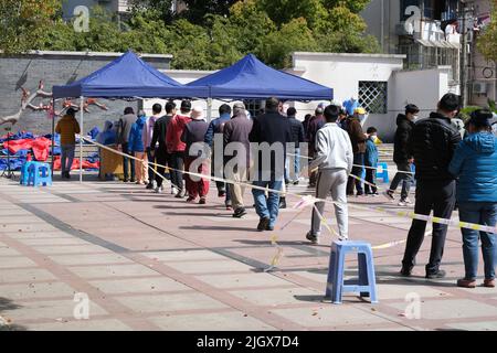 Shanghai,Cina-Marzo 24th 2022: Molte persone cinesi si allineano per ricevere test di massa di acidi nucleici Covid-19 nel quartiere residenziale. Shanghai è in un surg Foto Stock