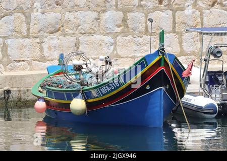 Un Luzzu maltese dipinto tradizionalmente, ormeggiato in mare a Marsalforn, Gozo, Malta Foto Stock