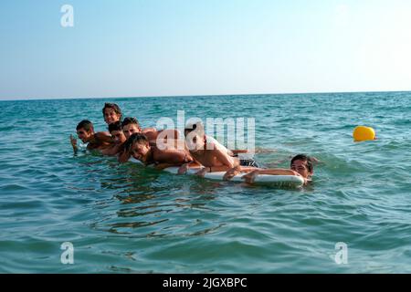 Una compagnia di giovani italiani ama la giornata estiva a Lido di Ostia. Foto Stock