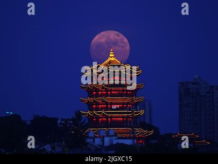 Wuhan, provincia cinese di Hubei. 13th luglio 2022. Una supermoon è raffigurata vicino alla Torre della Crane gialla a Wuhan, provincia centrale di Hubei, Cina, 13 luglio 2022. Credit: Zhou Guoqiang/Xinhua/Alamy Live News Foto Stock