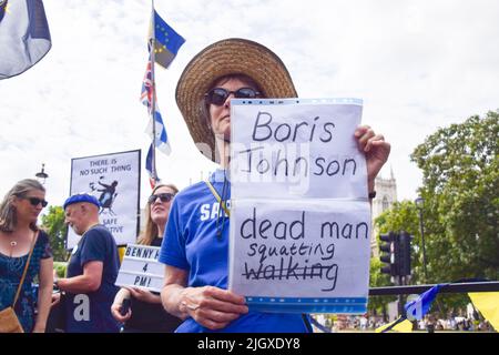 Londra, Inghilterra, Regno Unito. 13th luglio 2022. Un protessore al di fuori del Parlamento ha un segnale che recita ''Boris Johnson: Dead man squatting''. I manifestanti anti anti anti-Tory e anti-Boris Johnson si riunirono a Westminster, mentre Johnson affrontò le domande del suo primo Ministro dopo la dimission. I manifestanti chiesero di lasciare immediatamente l'ufficio. (Credit Image: © Vuk Valcic/ZUMA Press Wire) Foto Stock