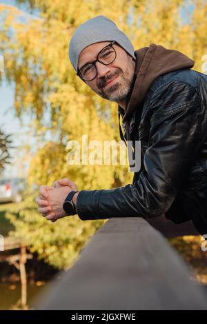 bell'uomo sorridente in giacca cappotto in autunno Foto Stock