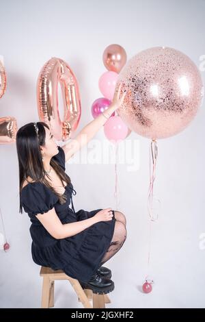 la giovane ragazza asiatica carina tocca una palla trasparente con i confetti Foto Stock