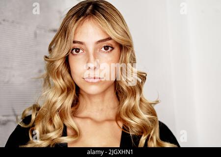 Ritratto di donna che mostra capelli appena pettinati al parrucchiere Foto Stock