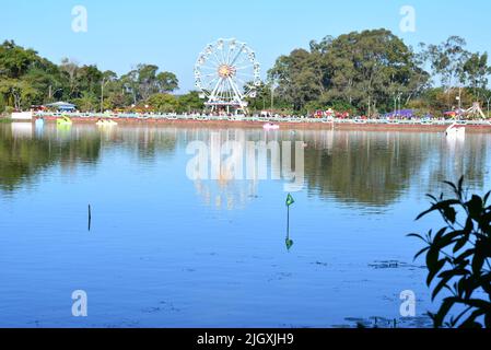 Lago con ruota Ferris sullo sfondo in primo piano bandiere del Brasile, con bandiere del Brasile e pedalò barche, Brasile, Sud America, selettivo foc Foto Stock