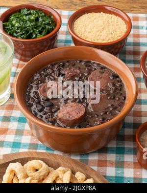 Tipica feijoada brasiliana con riso, caipirinha, farofa e cracklings. Foto Stock