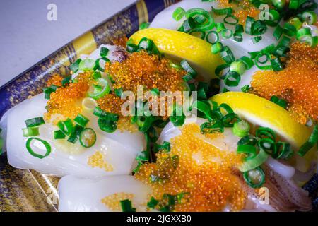 Un Ika Sushi da asporto (sushi di calamari) con Tobiko (Tobikko, uovo di pesce volante) e cipolla verde tritata in un vassoio Foto Stock