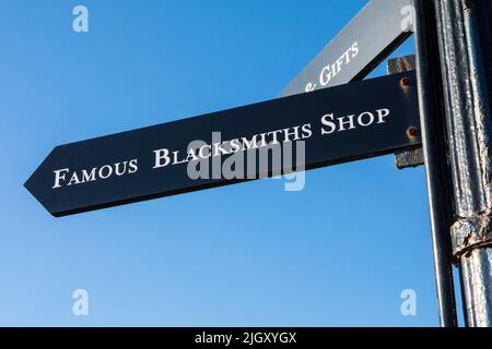 Gretna Green, Scozia - Ottobre 15th 2021: Un cartello che indica ai visitatori la direzione del famoso Blacksmiths Shop di Gretna Green, Scozia. Foto Stock