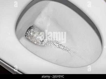 La vista closeup di uno scarico in una tazza di gabinetto Foto Stock