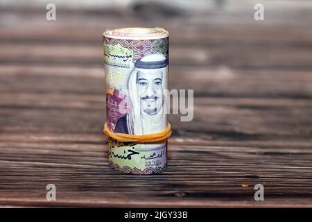 5 SAR cinque riyals Saudita banconote in denaro rotolate con fasce di gomma con la foto di re Salman e Shaybah petrolio raffineria, Arabia Saudita mon Foto Stock