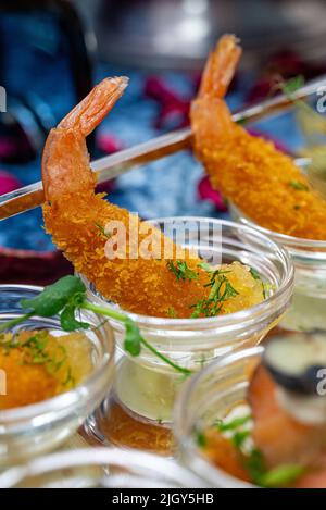 gamberi in pastella primo piano. piatto sul tavolo del buffet. Foto Stock
