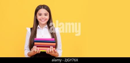 ragazza teen felice nella pila uniforme del libro della presa della scuola, lettura. Banner della studentessa scolastica. Ritratto della studentessa con spazio per la copia. Foto Stock