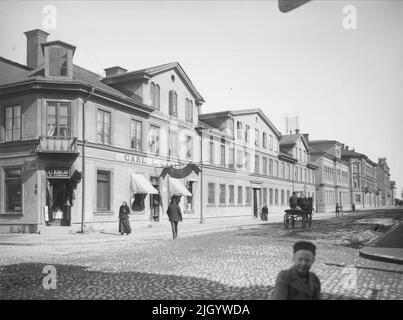 Vaksalagatan verso nord-est da Storgatan, Uppsala 1901 - 1902. Vaksalagatan a nord-est da Storgatan. Il quartiere intorno a Vaksalagatan ad est della ferrovia iniziò ad essere costruito già nel 1850s. La lunga lunghezza di due piani nella Fröj a sinistra fu eretta secondo il piano cittadino di Taube dal 1859. La lunghezza si estendeva fino alla prima piazza Vaksala, che fu un'edizione ampliata di Stora Torget. Nel 1880, la forma quadrata è stata cambiata e il quartiere di Fröjm è stato riempito contro Salagatan con la ben nota banca pegno per molti Uppsala e studenti. "Da Ola EHN & Gunnar Elfström, Foto Stock