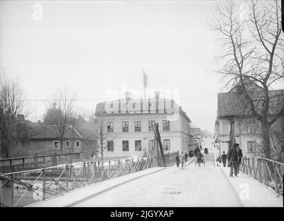 Järnbron sopra Fyrisån, ex Järnbrogatan, attuale St. Olofsgatan, Uppsala 1901 - 1902. Järnbrogatan (St Olofsgatan) verso sud-ovest dal ponte di ferro. Il Ponte di ferro fu costruito nel 1846 secondo i disegni di G T P Chiewitz. Nel 1964, il ponte è stato smantellato per consentire l'ampliamento di St. Olofsgatan secondo il piano cittadino del 1880. Sul lato occidentale del fiume si trova l'accademia master way's fattoria e le annessi a Walmstedtska fattoria. 'Da Ola EHN & Gunnar Elfström, la fine del secolo Uppsala nelle foto di Dahlgren. Natura e cultura 1977. Foto Stock