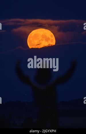 Lauder Moor, Scottish Borders, Regno Unito. 13th luglio 2022. Regno Unito la Supermoon il 13th 2022 luglio sorge attraverso le nubi basse viste da Lauder Moor nei confini scozzesi. Oscar Wilkinson, è rimasto fino a tardi per guardare lo spettacolo della natura. Stasera la luna piena è anche chiamata la luna buck ed è l'unico superman del 2022. Le Superlune sono categorizzate quando la Luna è a 360.000km (o meno) lontano dalla Terra nel suo percorso orbitale. Picture Credit: phil wilkinson/Alamy Live News Foto Stock