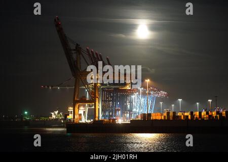 Amburgo, Germania. 13th luglio 2022. La luna piena sorge di sera sul porto di Amburgo. Allo stesso tempo, la luna è vicina alla terra, ed è per questo che appare più grande del solito ed è chiamata una superluna. Credit: Marcus Brandt/dpa/Alamy Live News Foto Stock