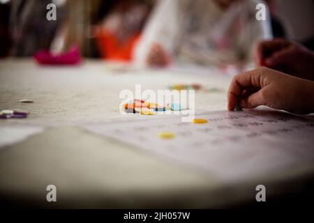 PRIMO PIANO DELLE MANI DI UNA SIGNORA ANZIANA IN UNA CURA ANZIANA HOME GIOCARE BINGO Foto Stock
