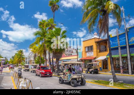 ISLA MUJERES, MESSICO - Apr 2022: auto da golf sulla strada tra le palme vicino Cancun. Foto Stock