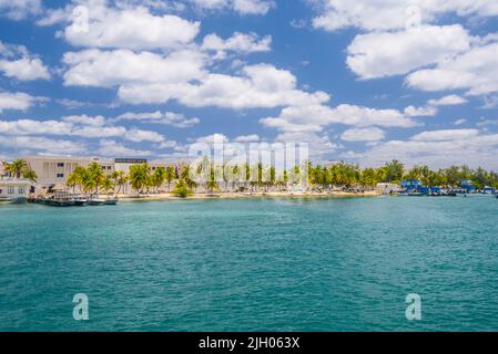 Barche vicino alla costa con palme dell'isola Mujeres nel Mar dei Caraibi, Cancun, Yucatan, Messico. Foto Stock