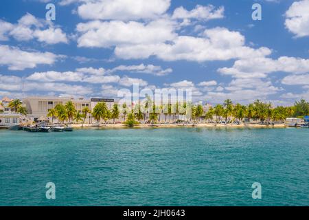 Barche vicino alla costa con palme dell'isola Mujeres nel Mar dei Caraibi, Cancun, Yucatan, Messico. Foto Stock