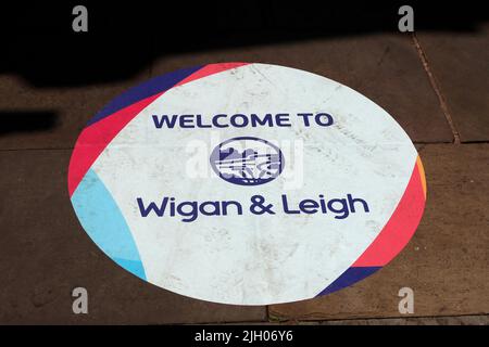 Benvenuti a Wigan & Leigh, segno sul marciapiede, mercato di Leigh, Lancs, Inghilterra, REGNO UNITO, WN7 4LA Foto Stock