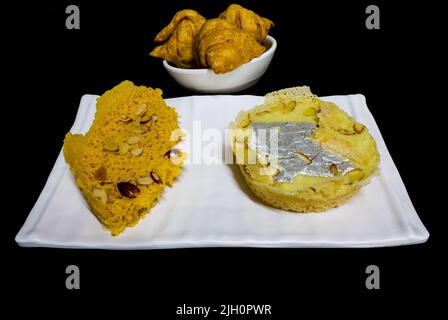 Khoya Ghevar o Malai Ghewar è dolce indiano fatto su Teej,Janmashtami,Raksha Bandhan in Rajasthan,Punjab,UP,India.Vista frontale di ghewar,samosa. Foto Stock