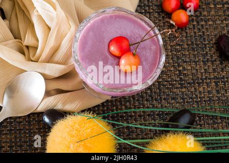 Jamun Mousse o Black Plum Mousse con ciliegie.Fresh, dessert vegano fatto in casa.Vista dall'alto, primo piano di ciotola isolato su sfondo scuro.spazio copia. Foto Stock