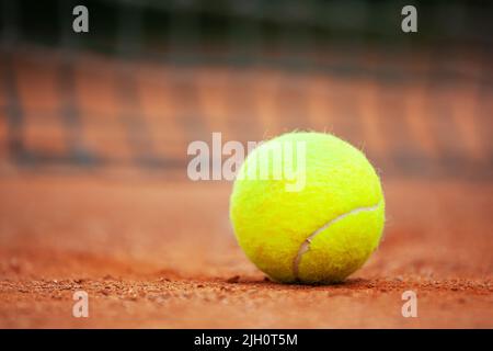 Giallo palla da tennis si trova sull'argilla corte vicino. Foto Stock