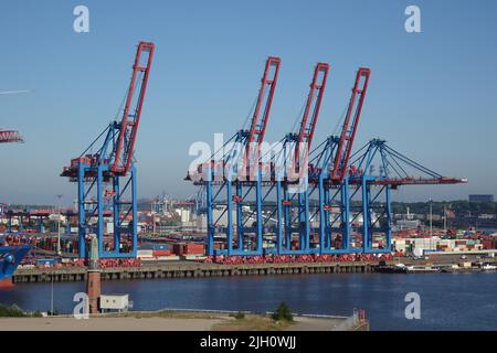 Gru nel porto di Amburgo Still e attendere la prossima nave container per scaricare container con merci provenienti dall'estero. Foto Stock